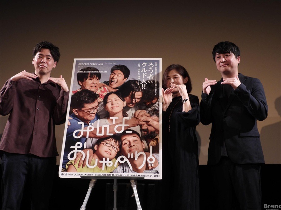 映画『みんなおしゃべり』のポスターを中央に挟み、ステージ上に並ぶ3人の人物。左から河合健監督、東京大学バリアフリー推進オフィス特任講師の中津真美氏、作家の五十嵐大氏。