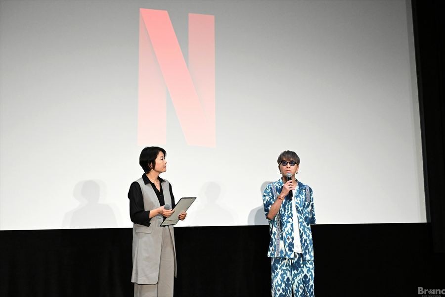 ステージのスクリーンにネットフリックスのロゴが映し出される中、マイクを持って話すSUPER EIGHTの安田章大氏(右)と、隣で進行役を務める吉野菜穂子氏(左)。